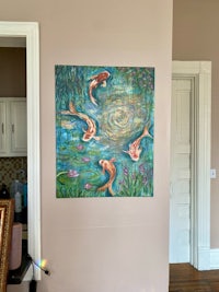 a painting of koi fish in a living room