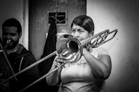 black and white photo of a woman playing a trombone