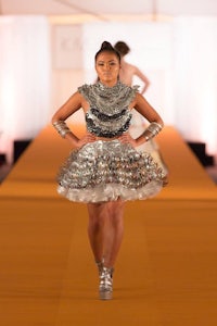 a model walks down the runway in a silver dress