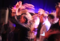 a blurry image of people dancing at a concert